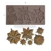 Decorative metal flower mold with embossed patterns and finished metal flowers on a white background