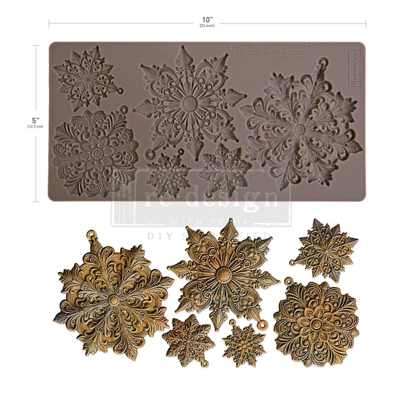 Decorative metal flower mold with embossed patterns and finished metal flowers on a white background