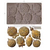 Decorative mold with intricate designs and gold-colored castings on a white background