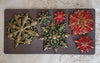 Decorative snowflake-shaped molds on a gray mat with a floral patterned background.