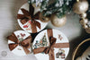 Decorative gift boxes with Christmas designs and ribbons on a wooden surface.