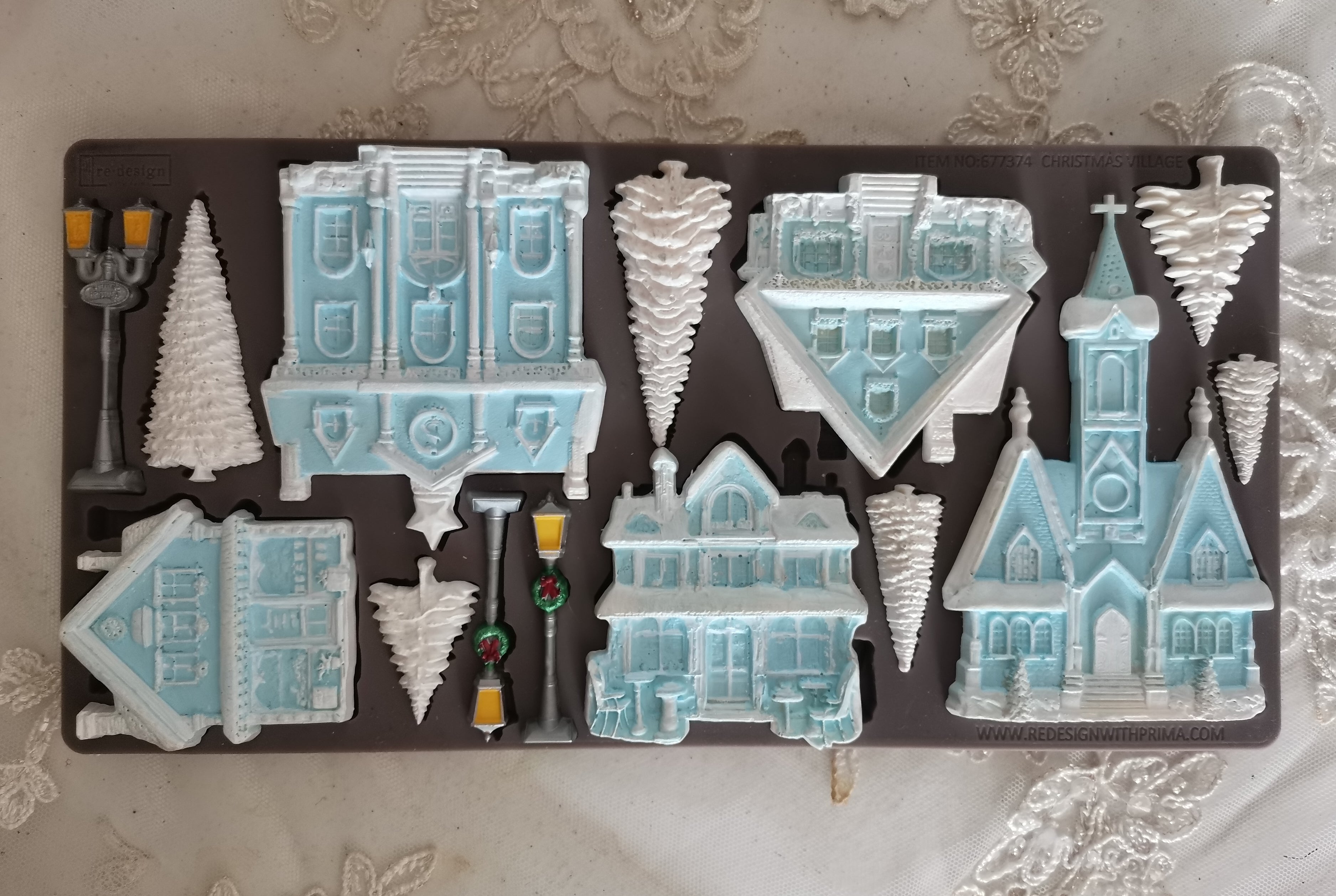 Decorative mold with winter-themed houses and trees on a decorative surface