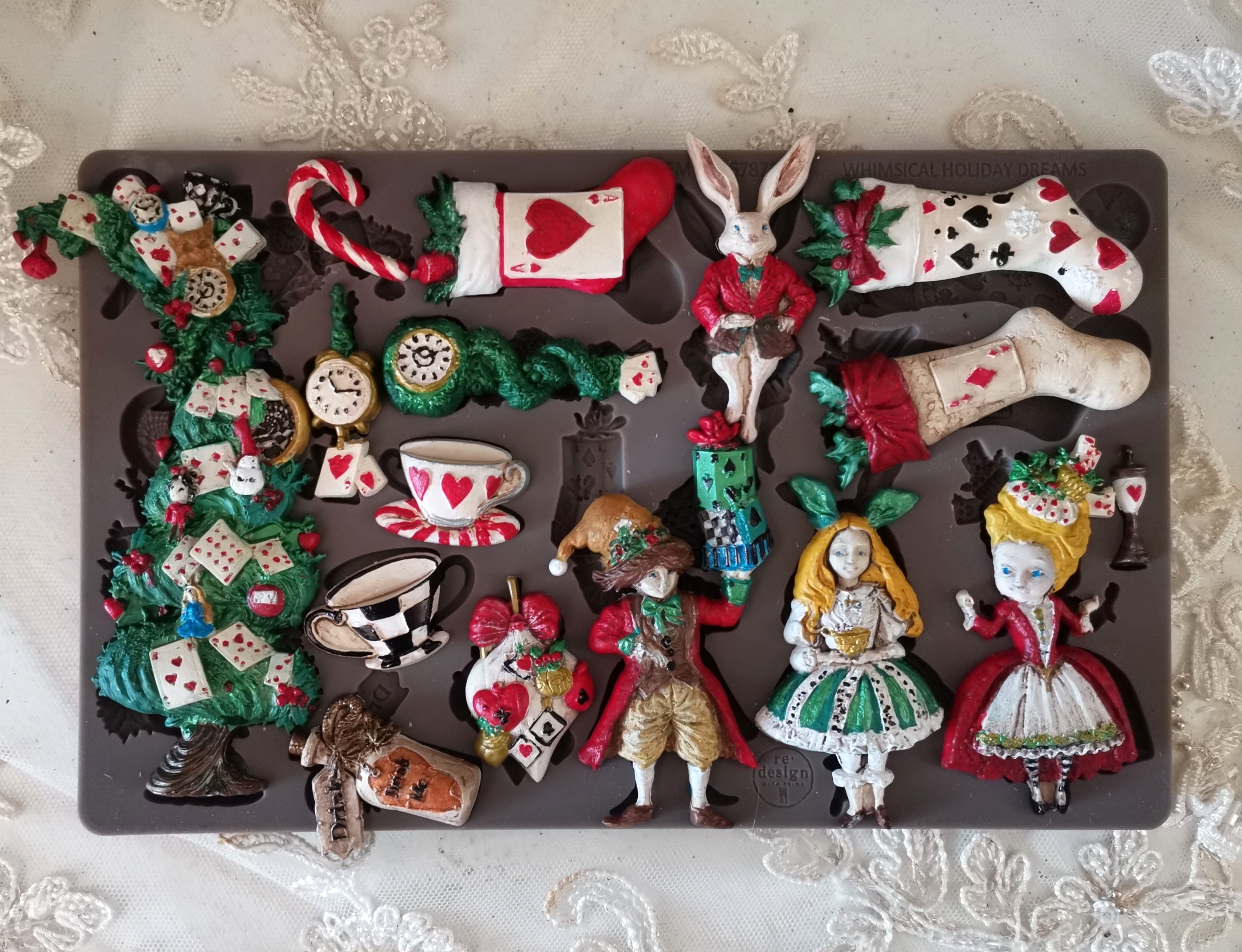 Collection of decorative figurines inspired by Alice in Wonderland on a dark surface.