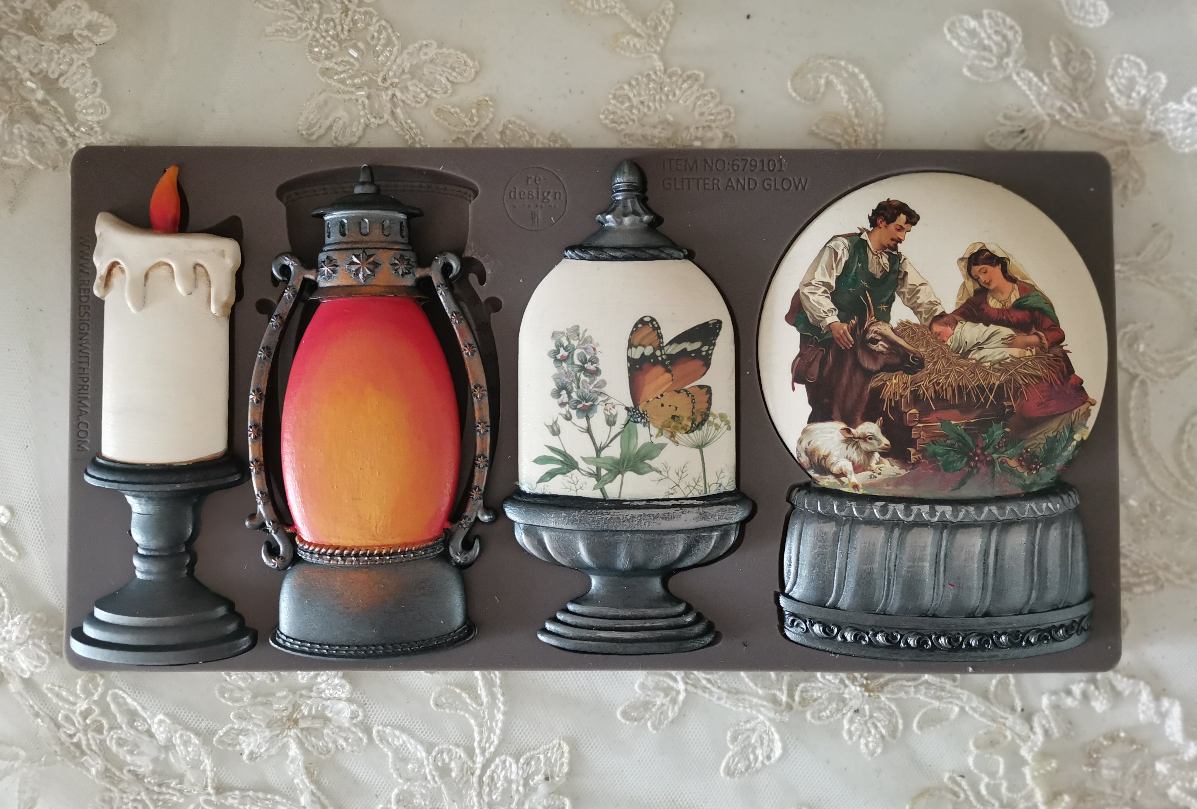 Decorative mold set with candle, lantern, and couple design on a textured surface.