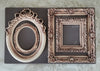 Two ornate picture frames on a textured surface