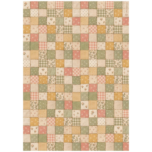 A rectangular patchwork quilt or rug featuring a grid of small square fabric panels in muted tones of sage green, dusty pink, mustard yellow, and cream, with various patterns including gingham, stripes, florals, and dots.