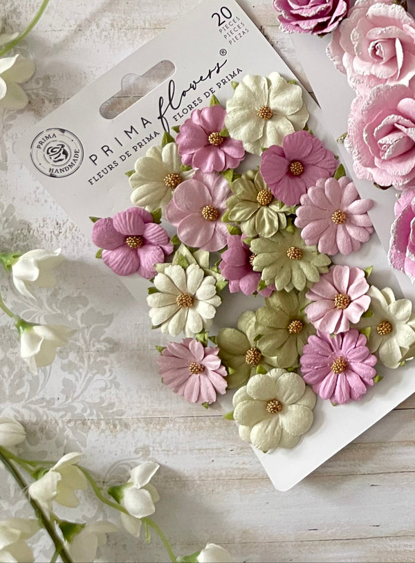 An array of hand-picked artificial flowers in varying shades of pink, white, and green, with an emphasis on floral embellishments.