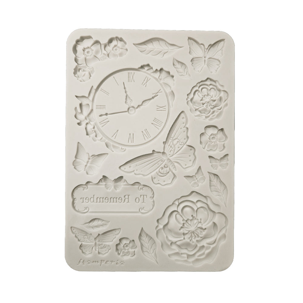 Decorative mold with clock design, flowers, and butterflies on a white background