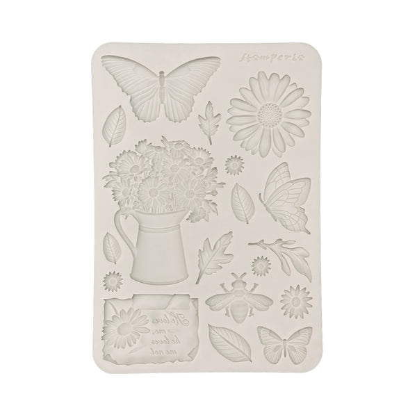 Decorative silicone mold with floral and butterfly designs on a white background