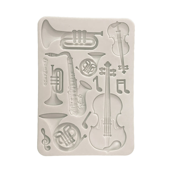 Silicone mold with musical instrument shapes on a white background