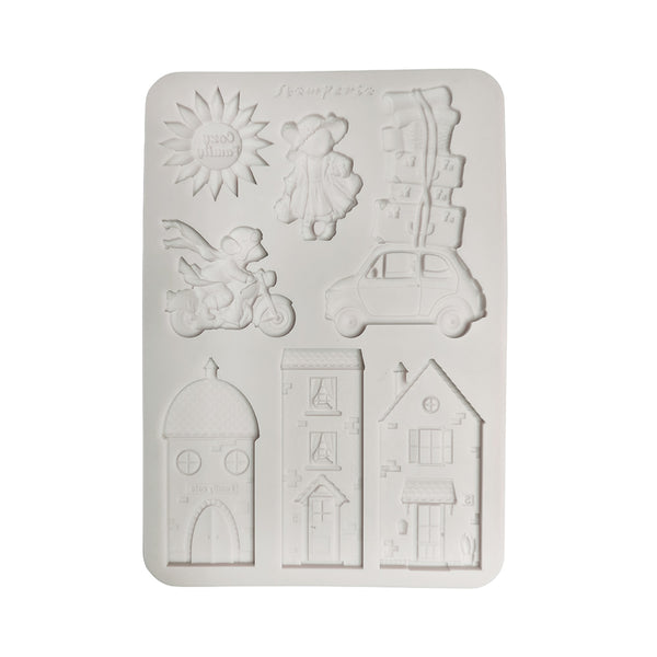 A white rectangular silicone mold with six embossed cartoon-style shapes, including a sun, a child, a scooter, a car, stacked boxes, and three house designs, shown on a plain white background.