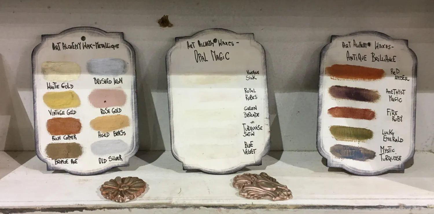 Three small boards with color swatches and labels on a white surface.